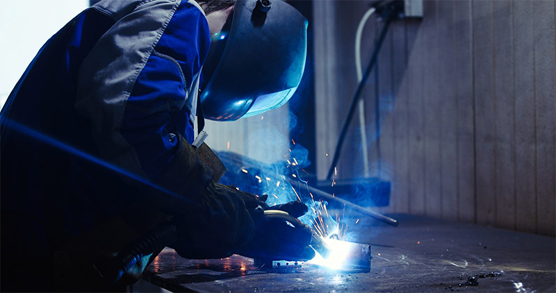 Metal worker welding in metal industry factory
