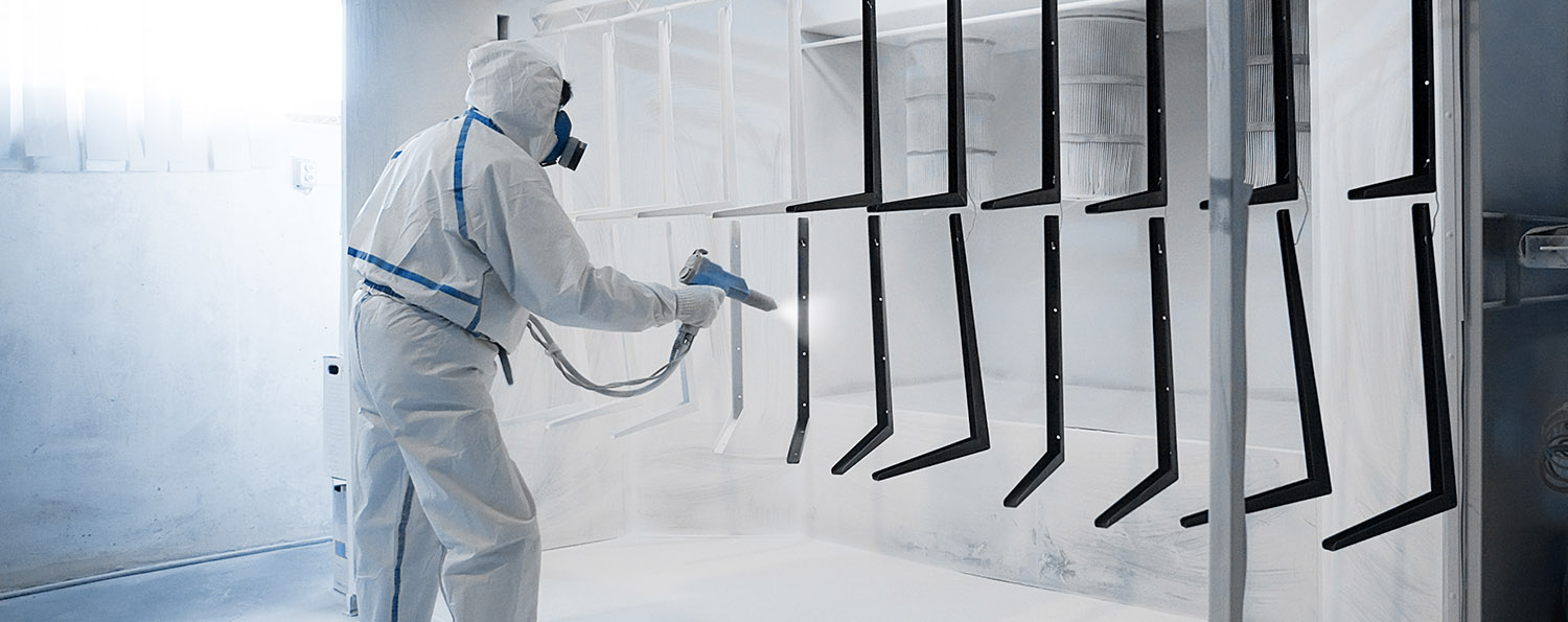 Man doing powder coating in spray booth